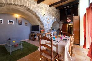 uma sala de jantar com uma mesa e uma parede de pedra em JARDIN STE ANNE em Carcassonne