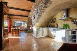 a kitchen with white cabinets and a tile floor at JARDIN STE ANNE in Carcassonne