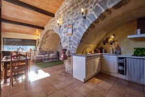 uma cozinha e sala de estar com uma parede de pedra em JARDIN STE ANNE em Carcassonne