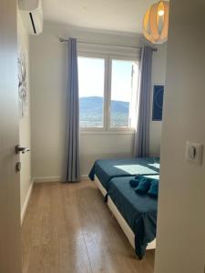 - une chambre avec un lit et une grande fenêtre dans l'établissement Superbe appartement en centre ville, à Porto-Vecchio