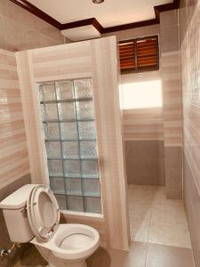 La salle de bains est pourvue de toilettes et d'une fenêtre. dans l'établissement SISAVANG HOTEL, à Vang Vieng