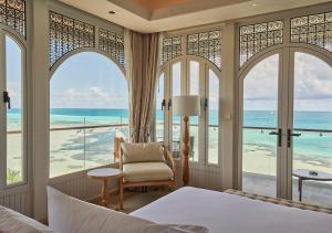 Stone Hotels Dhiffushi في ديفوشي: غرفة نوم مع سرير وإطلالة على المحيط