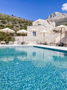 una gran piscina con sillas y sombrillas en Eleonas Limeni, en Limeni
