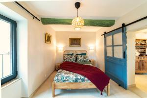 een slaapkamer met een bed met een blauwe deur bij Gîtes dans un mas en pierres au coeur d'un domaine viticole du Pic Saint-Loup in Corconne