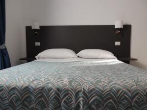 a bed with a black headboard and two pillows at Madonna della Neve in Rome