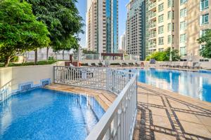 a swimming pool in a city with tall buildings at Fountainview Luxe 1BR, sleeps 4 in Dubai