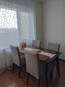 a dining room table with chairs and a box on it at Roses Apartment in Frýdek-Místek