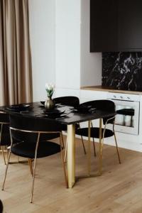 キェルツェにあるLuxury R11 Apartamentの黒いテーブル(椅子2脚付)、テレビが備わります。