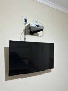 a flat screen tv on a wall with a projector at Pousada Casa do Jova em Raposo RJ 