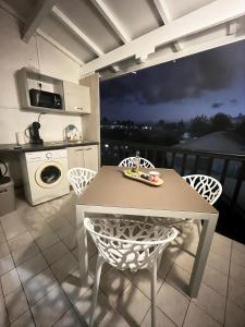 a kitchen with a table and chairs in a room at Azuri Lodge Duplex Marina in Saint-François