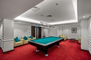 a billiard room with a pool table and chairs at Fountainview Luxe 1BR, sleeps 4 in Dubai