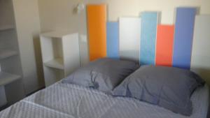 Bett mit farbenfrohem Kopfteil in einem Schlafzimmer in der Unterkunft Gîte Amour D'ardèche in Saint-Sernin