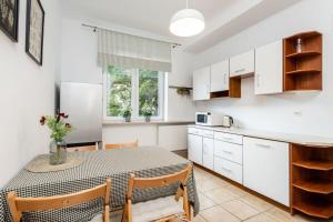 a kitchen and dining room with a table and chairs at Coriander Apartment City Center in Warsaw
