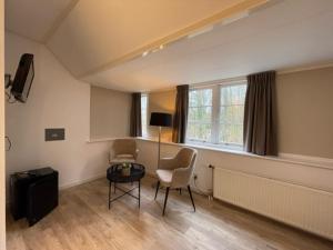 ein Wohnzimmer mit 2 Stühlen und einem Tisch in der Unterkunft Hotel Randduin in Oostkapelle