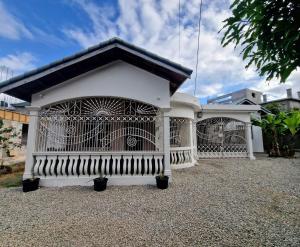 a white building with a gate in a yard at Spanish Palm Villa in Spanish Town