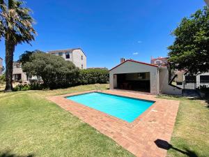 a swimming pool in the yard of a house at Laguna Beach K60 - Greenways Golf Estate on Sea in Cape Town