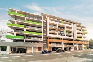 um prédio de apartamentos com dois carros estacionados em frente em Spacious 3 bed apartment near airport with parking em Sydney