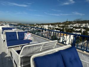 a balcony with wicker chairs and a view of a city at Misk Villa - Boutique Hotel & Spa in Sidi Bou Saïd