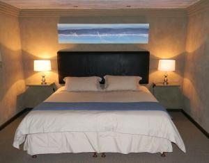 ein Schlafzimmer mit einem großen Bett mit zwei Lampen in der Unterkunft Stonehill River Lodge by Dream Resorts in Buffeljagsrivier