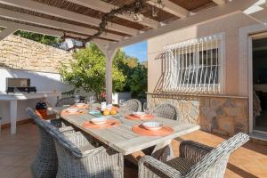 uma mesa de madeira e cadeiras num pátio em ¡Villa with sea views and private pool! em Alicante