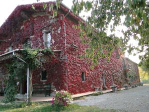 a red building covered in plants and flowers at Agriturismo Casanuova in Carobbio