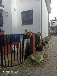 a fence in front of a building with potted plants at Hotel-hostel Saska in Warsaw