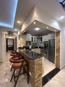 a kitchen with a large island in the middle of a room at Decent brand new flat with garden view in New cairo