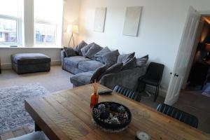 a living room with a couch and a table at Heswall apartment in Wirral