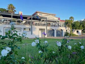 a building with a balcony and flowers in the yard at Laguna Beach K60 - Greenways Golf Estate on Sea in Cape Town