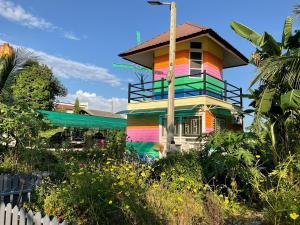 une maison colorée avec une clôture devant elle dans l'établissement PZ วิวล์, à Ban Mae Lai