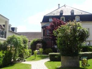 a large house with a walkway in front of a yard at Studio Maison Fyot in Dijon