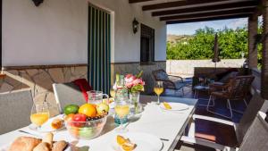 een tafel met een fruitschaal en een glas wijn bij Cortijo Antonio in Nerja