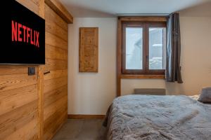 um quarto com uma cama e uma janela em Megève - Appartement - 1 Chambre em Demi-Quartier