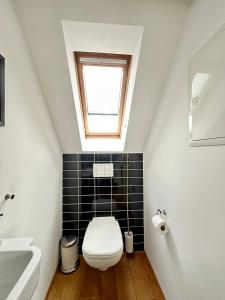ein Badezimmer mit Toilette und Fenster in der Unterkunft Moderne Apartments in attraktivem Altbau in Freiburg im Breisgau + 17 Fotos