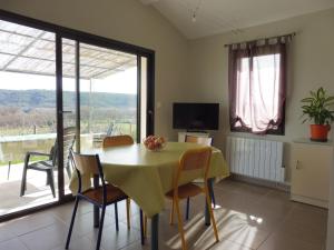 eine Küche und ein Esszimmer mit einem Tisch und Stühlen in der Unterkunft Gîte Amour D'ardèche in Saint-Sernin