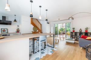 eine Küche und ein Wohnzimmer mit einem Tisch und Stühlen in der Unterkunft Maison avec jardin aux portes de Paris in Gentilly