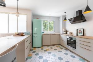 eine Küche mit einem türkisfarbenen Kühlschrank und weißen Schränken in der Unterkunft Maison avec jardin aux portes de Paris in Gentilly