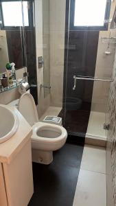 a bathroom with a toilet and a shower at Cozy 54 sqm one bedroom unit with 400 mbps WI-FI and sunset skyline view in Manila