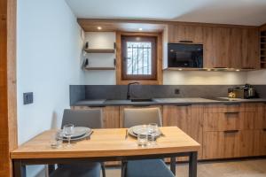 uma cozinha com uma mesa de madeira com copos de vinho em Megève - Appartement - 1 Chambre em Demi-Quartier