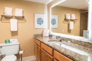 Un baño con lavabo, inodoro y espejo. en Attractive Oceanfront King Room 5th Flr, en Pawleys Island