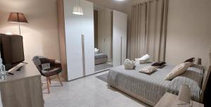カンポバッソにあるLa Maison - Short Rentalのベッドとテレビが備わるホテルルームです。