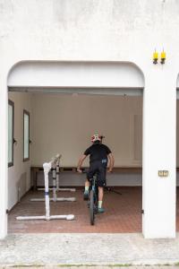 Un uomo in bicicletta in un garage di Hotel Continental a Pietra Ligure