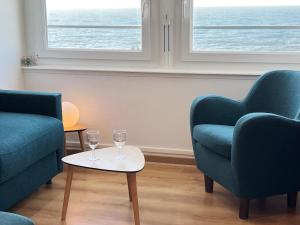 uma sala de estar com duas cadeiras e dois copos numa mesa em Fenêtres sur mer em Cayeux-sur-Mer