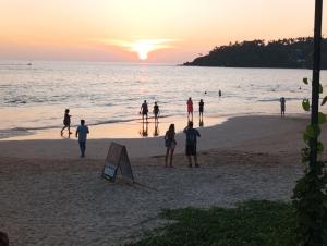 a group of people on the beach at sunset at Bisandu guesthouse in Mirissa