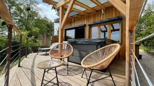 eine Terrasse mit zwei Stühlen und einem Grill auf einem winzigen Haus in der Unterkunft Logis hôtel Le Saint Antoine in Lamarche-sur-Saône