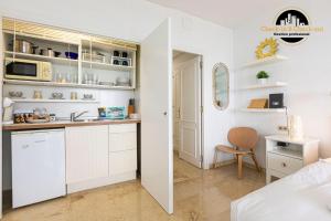 a kitchen with white cabinets and a sink in a room at Apartamento Castillo Santa Clara 1º Linea El Trasval in Torremolinos