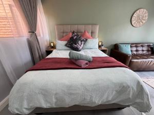 a bedroom with a large bed with two pillows at Afrique134 Olive Tree Private Courtyard Suite in Pretoria