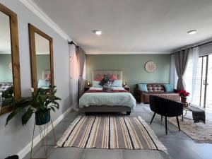 um quarto com uma cama e um sofá em Afrique134 Olive Tree Private Courtyard Suite em Pretoria