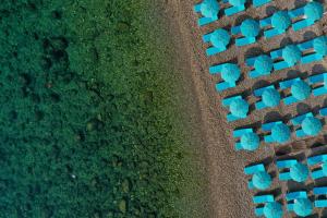 een uitzicht over een park met blauwe stoelen bij La Plage Resort in Taormina