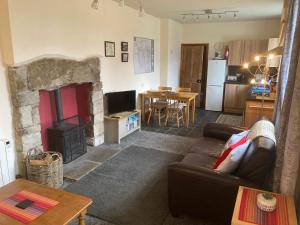 a living room with a couch and a fireplace at Station House Self Catering, Catton in Hexham